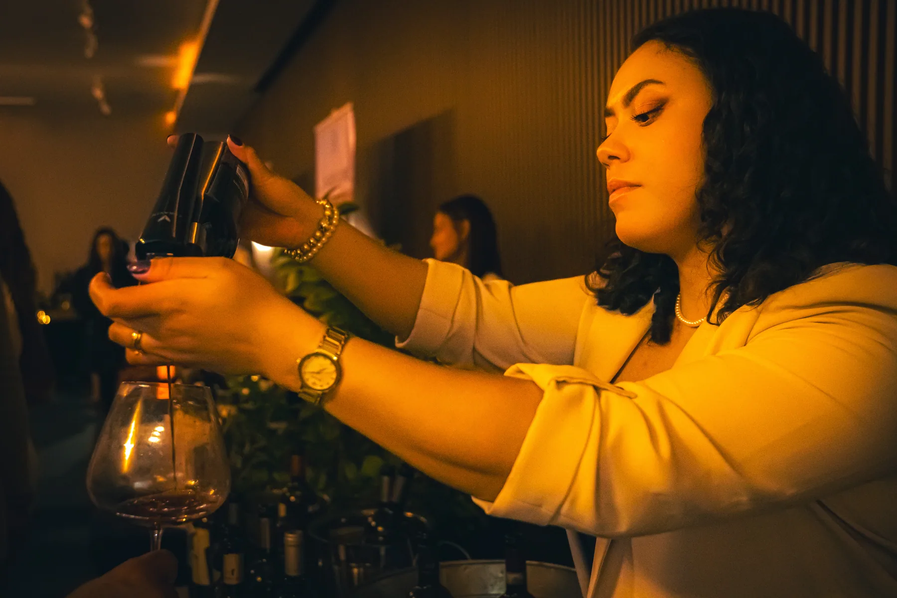 Mujer sirve vino en una copa durante una cata.
