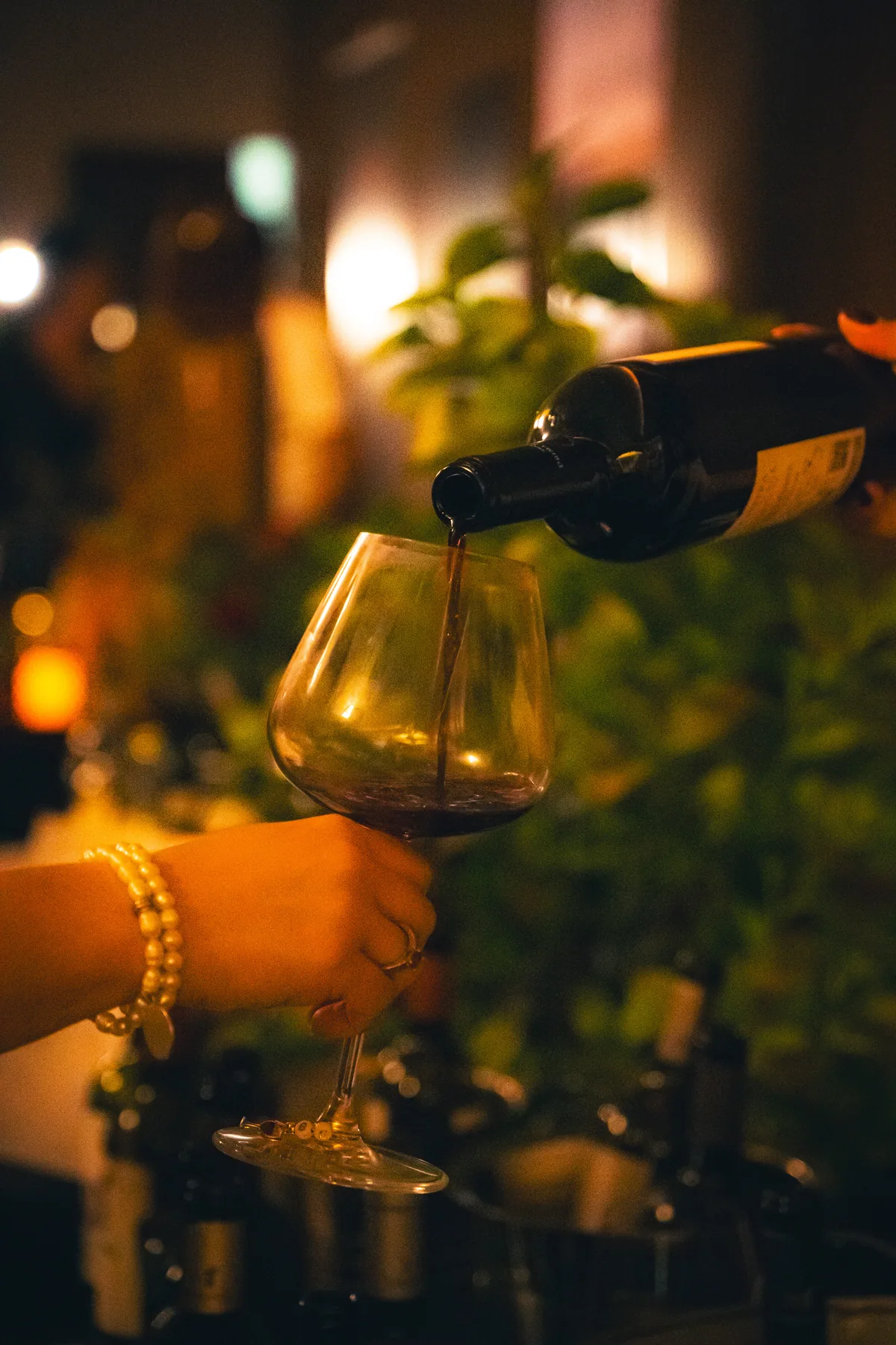 Vino servido en una copa junto a una mesa de degustación.
