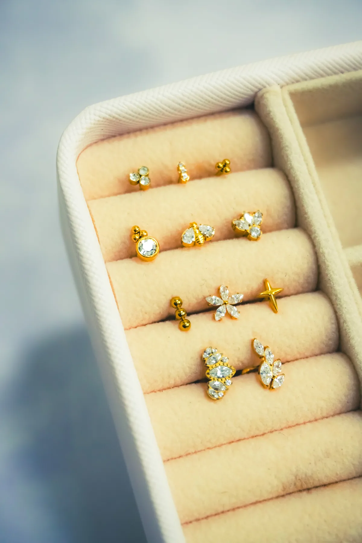 Anillos dorados alineados en una bandeja de joyería.