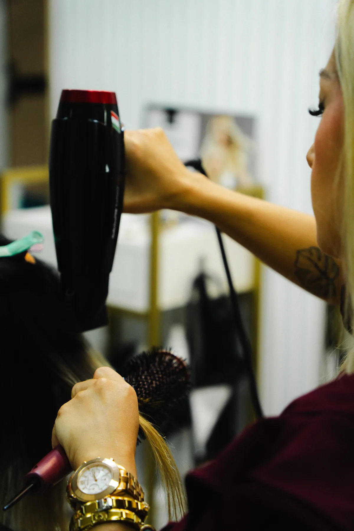Estilista seca el cabello de una clienta en el salón.