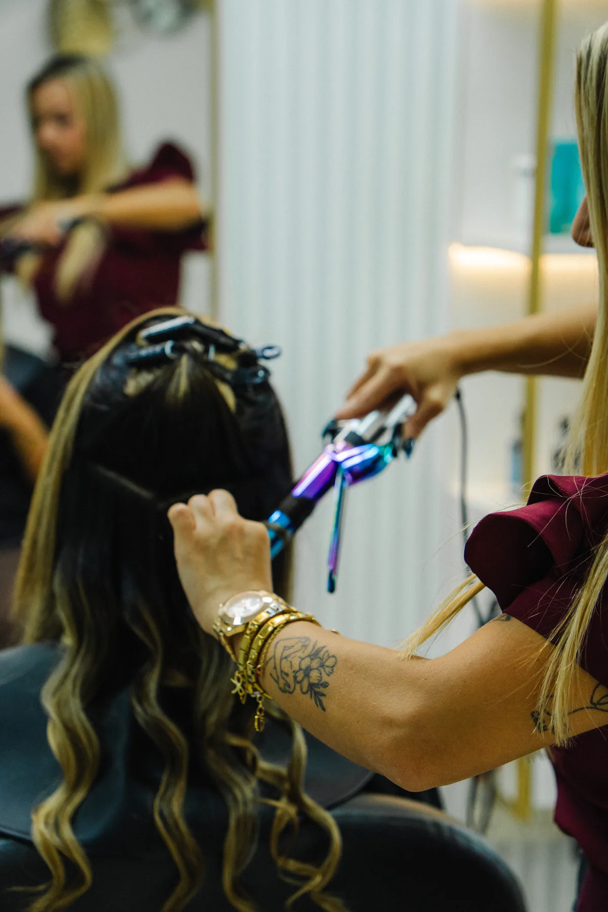 Detalle de una estilista dando forma al cabello de su clienta.