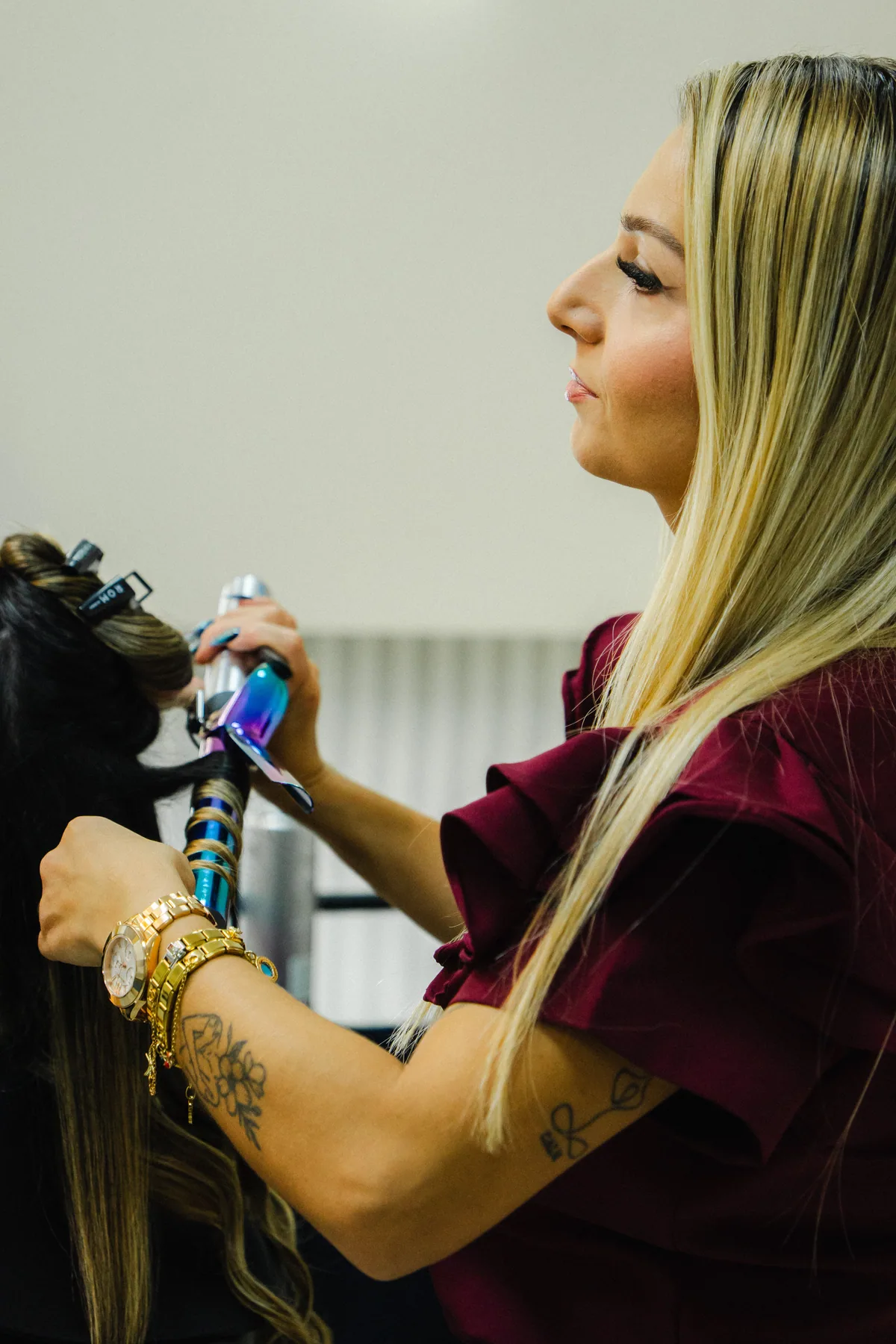Estilista peina el cabello de una clienta en un salón.
