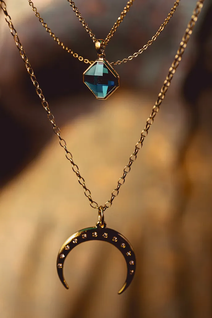 Collares dorados en capas con dijes azul y de media luna