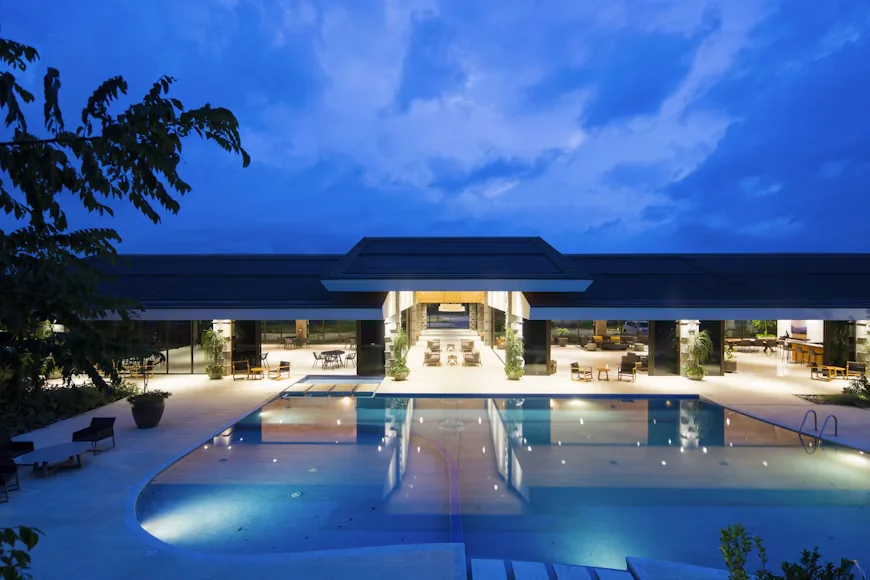 Edificio y piscina iluminados al anochecer