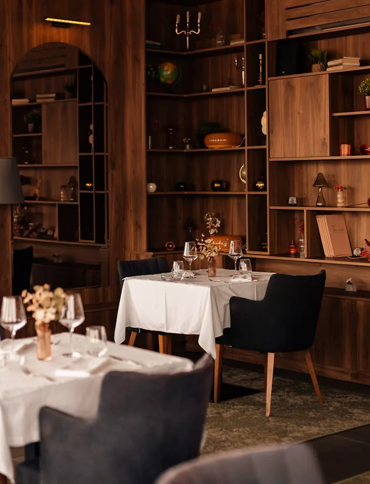 Mesa preparada en restaurante con mobiliario y estanterías de madera