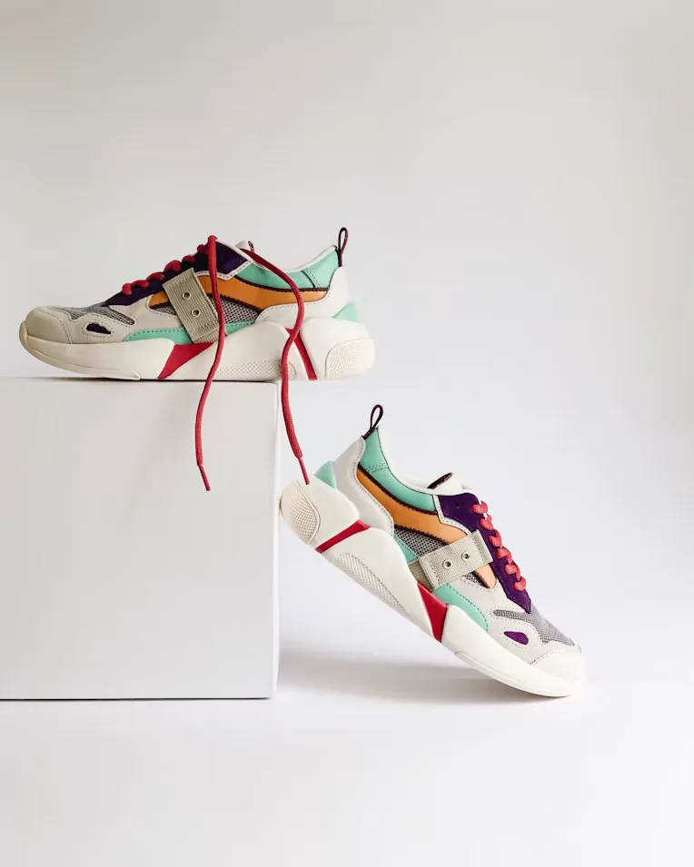 Par de tenis de colores fotografiados sobre fondo claro