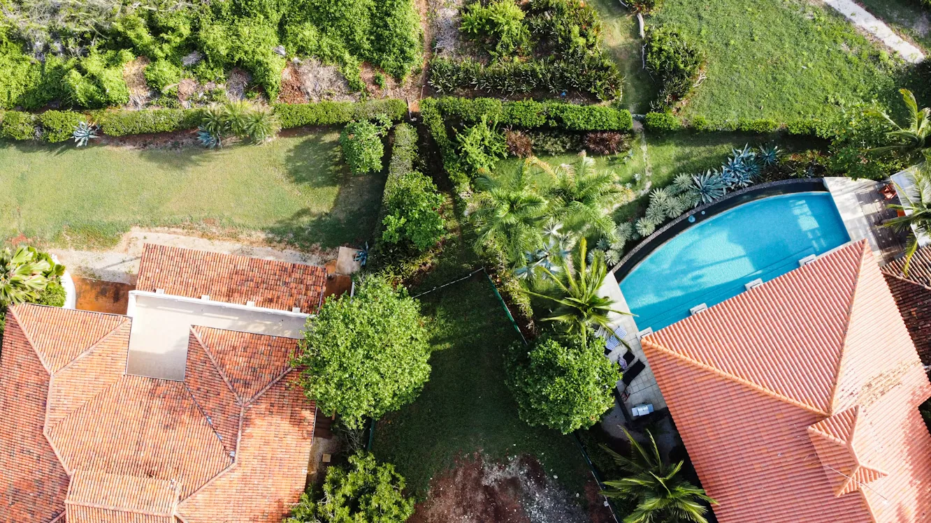 Vista aérea de propiedad con piscina y jardines